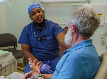 Healthcare provider discussing care with senior patient in clinical consultation room